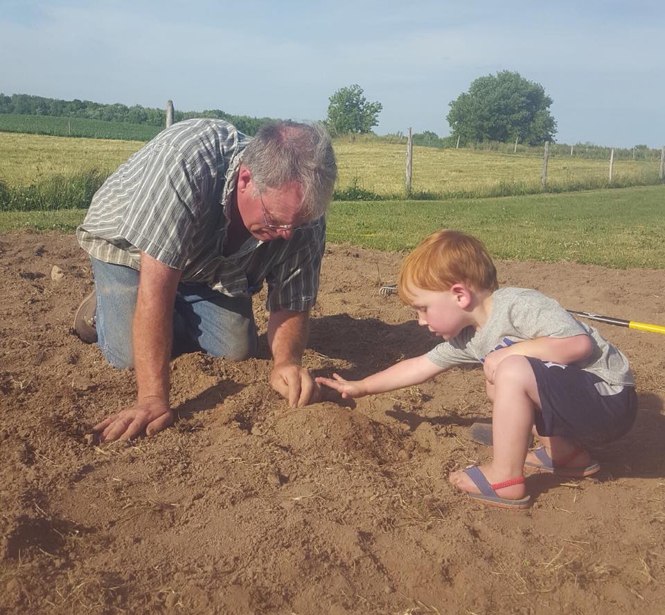 man and young boy digging in the dirt