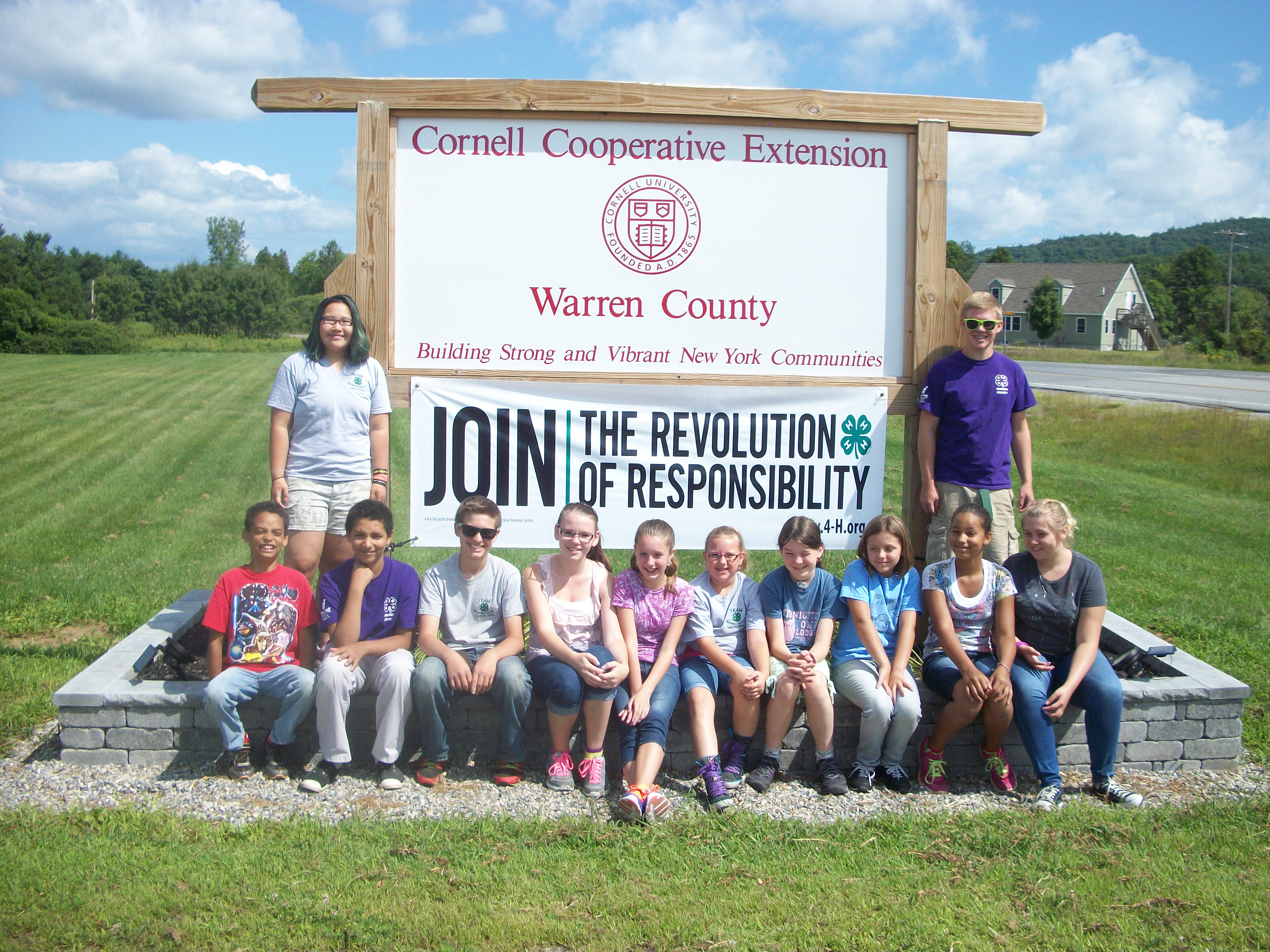 4-H Youth standing in front of CCE sign.