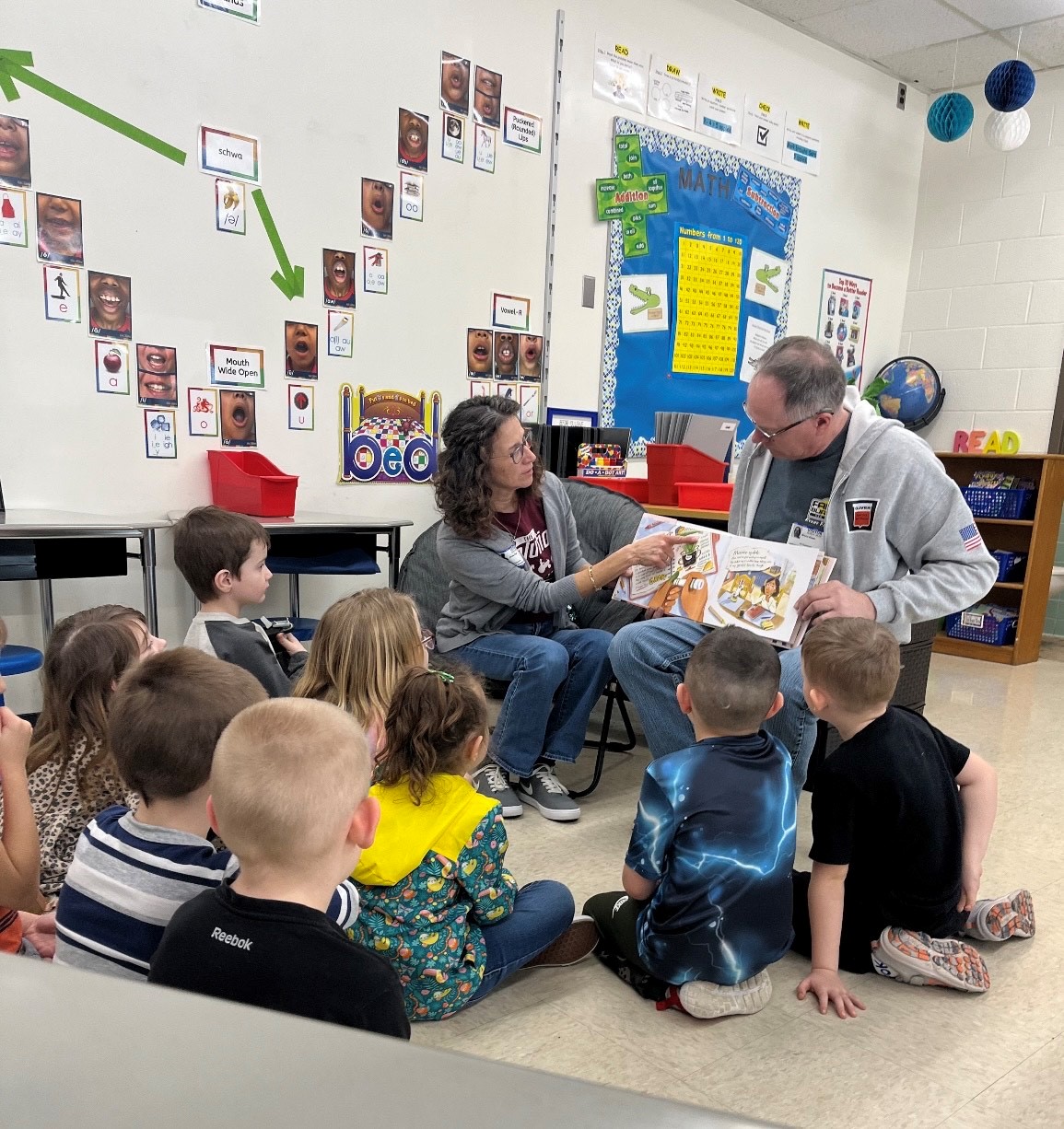 An Educator reads a book to youth