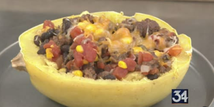 spaghetti squash boat filled with ground beef, onions, tomatoes, beans, and cheese