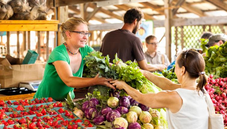 Woman purchasing produce at farmers market