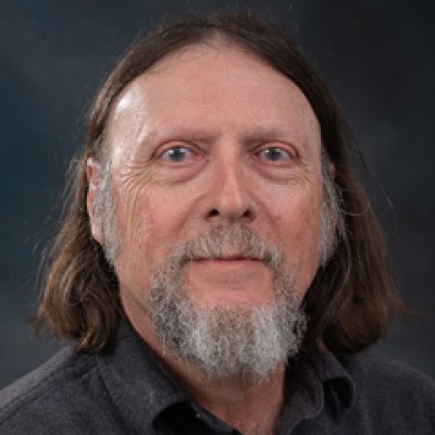 Headshot of Robert Hadad: A man wearing a dark colored, collared shirt.