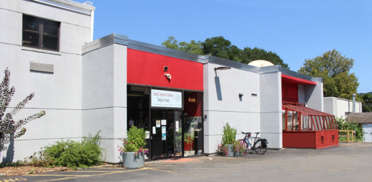 View of the front of the CCE Tompkins building, with bike rack and greenhouse.