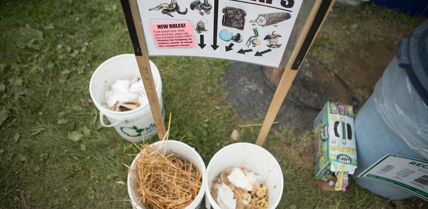 Three buckets sit below a sign that reads "Food Scraps"