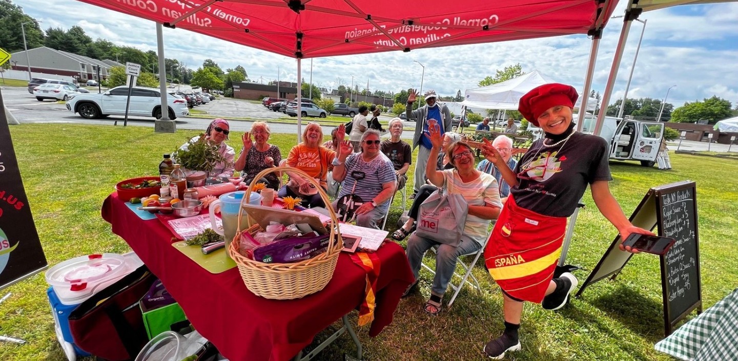 Farmers Market visitors watch a cooking demonstration 