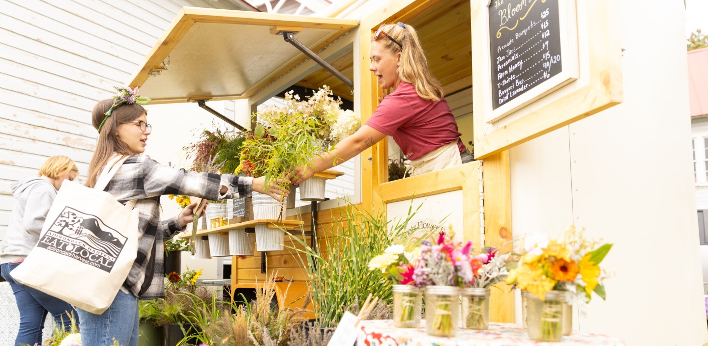woman selling flowers to customer at festival