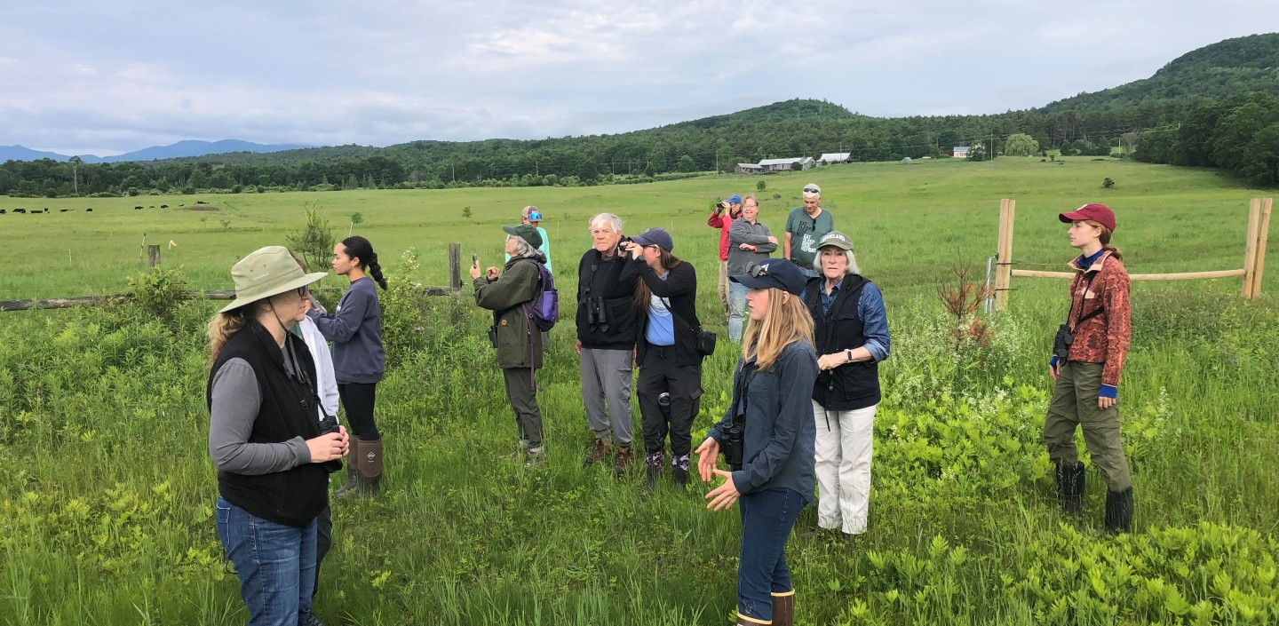 A group of people stand in a field together