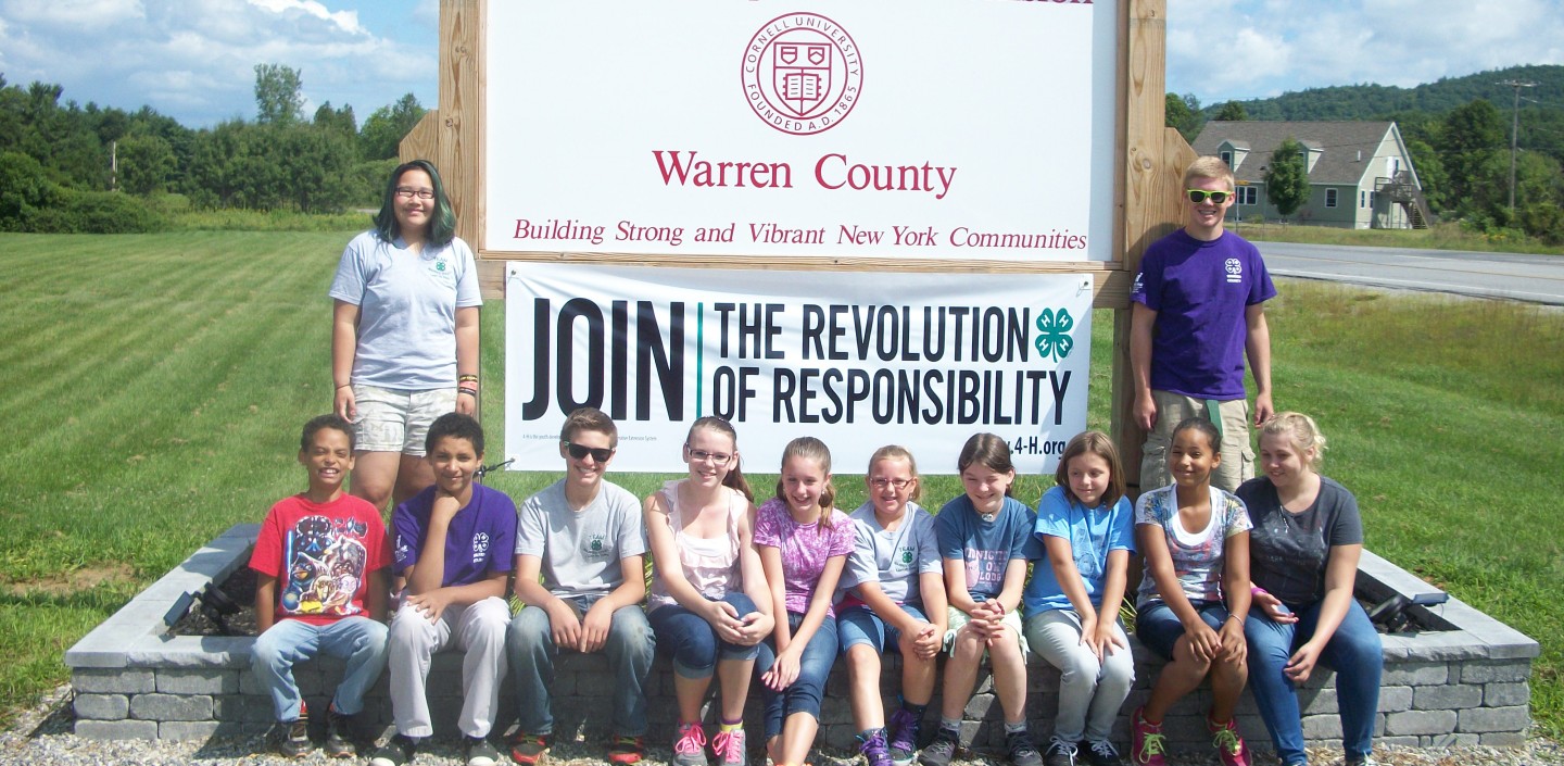 4-H Youth standing in front of CCE sign.