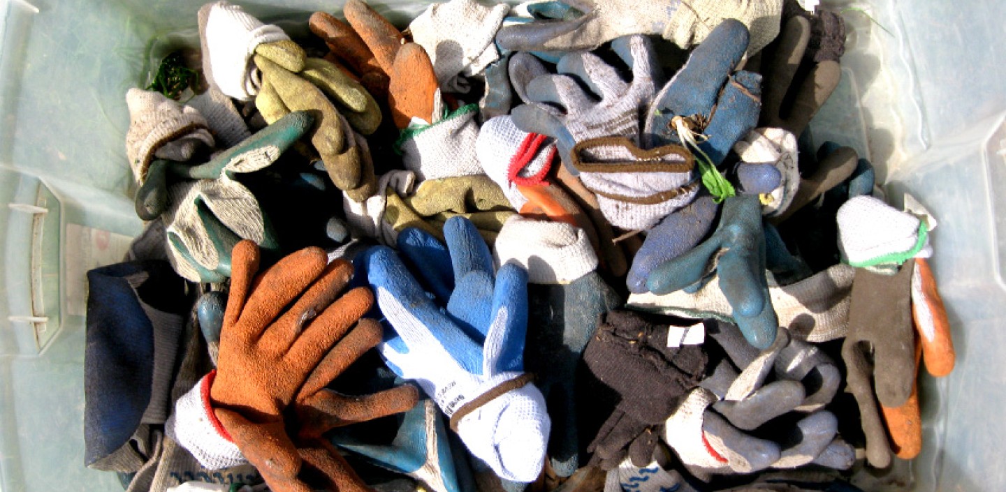 A plastic bin full of gardening gloves