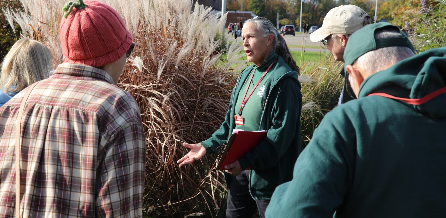 A Master Gardener Volunteer teaching a group about Fall clean-up methods.
