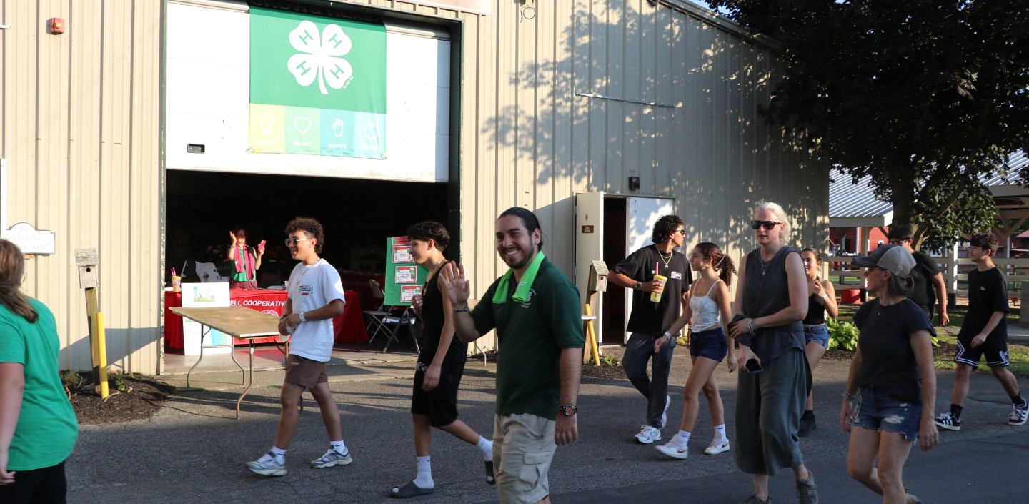 A group of people walk past the Jane W. Barley Memorial Youth Building during the 2025 Ulster County Fair Parade.
