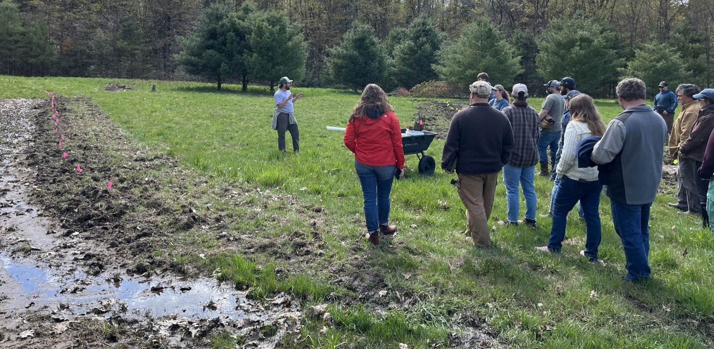 More than a dozen people on a farm tour listening to a man talking about ag climate resiliency measures he has taken on the farm.