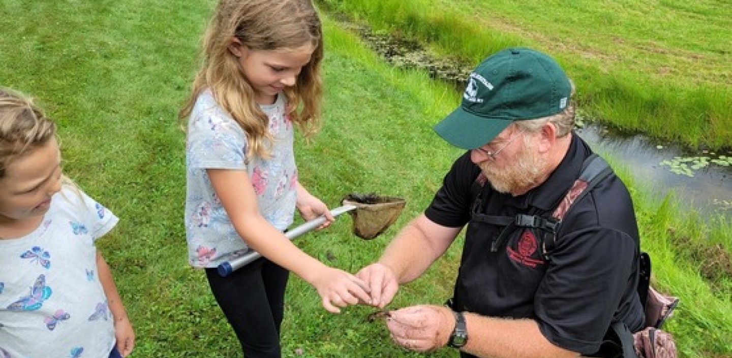 a man and child inspecting an insect