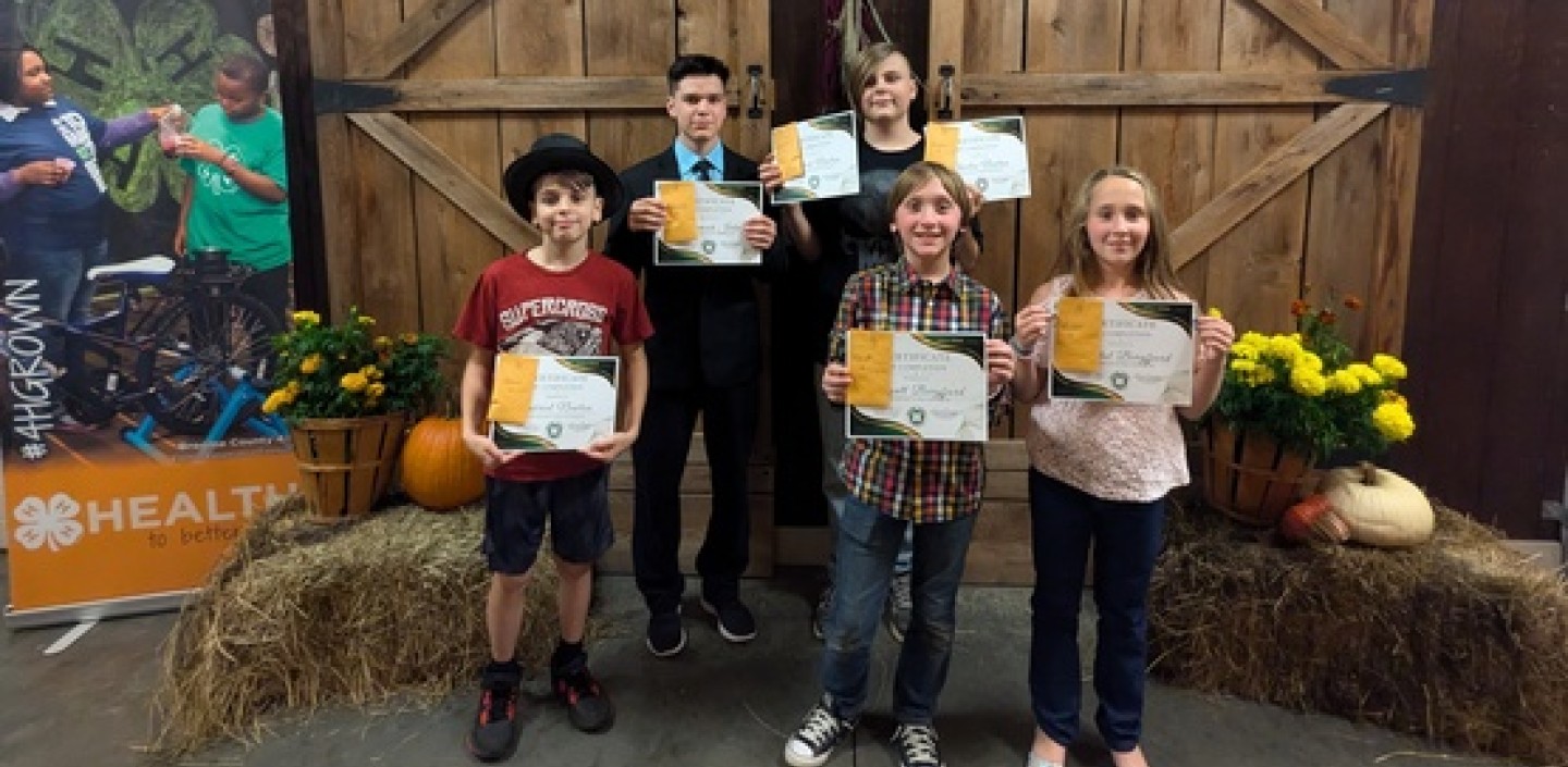 a group of 4-H youth receiving award certificates