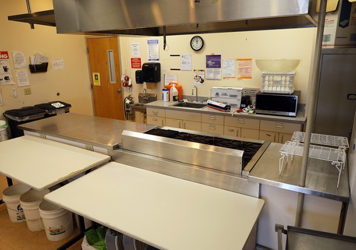 View of stoves, countertops, and kitchen appliances in a kitchen space.