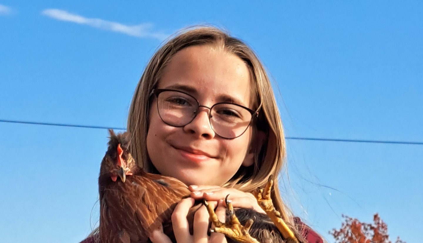 A girl holds a chicken