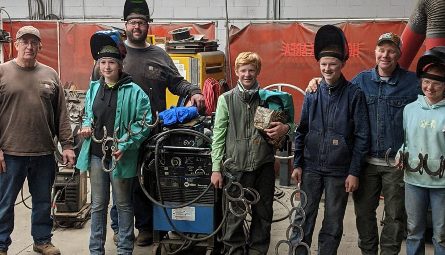 several youth and adults in welding gear