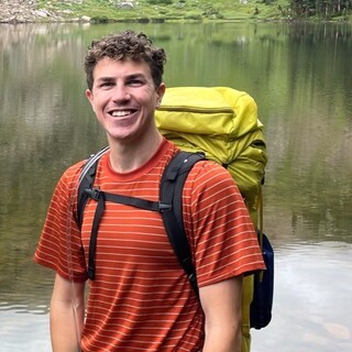 Picture of Max Kelly in front of a stream