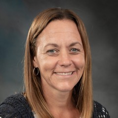 Headshot of Christy Hoepting: Smiling woman with dark sweater on.