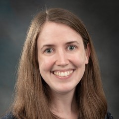 Headshot of Margie Lund: Smiling woman with a dark colored, collared shirt.
