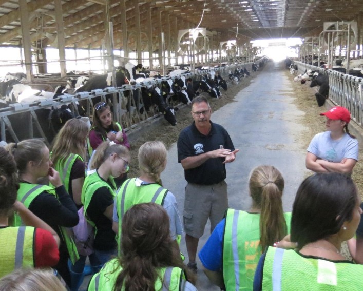 youth talking to farmer in dairy barn