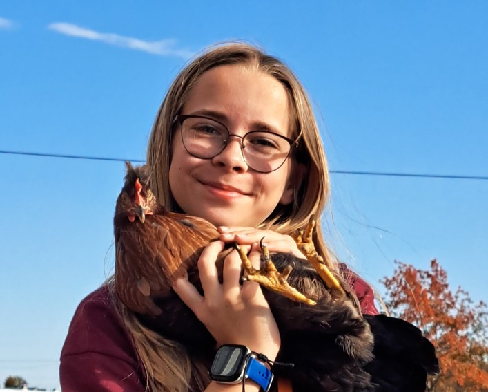 A girl holds a chicken