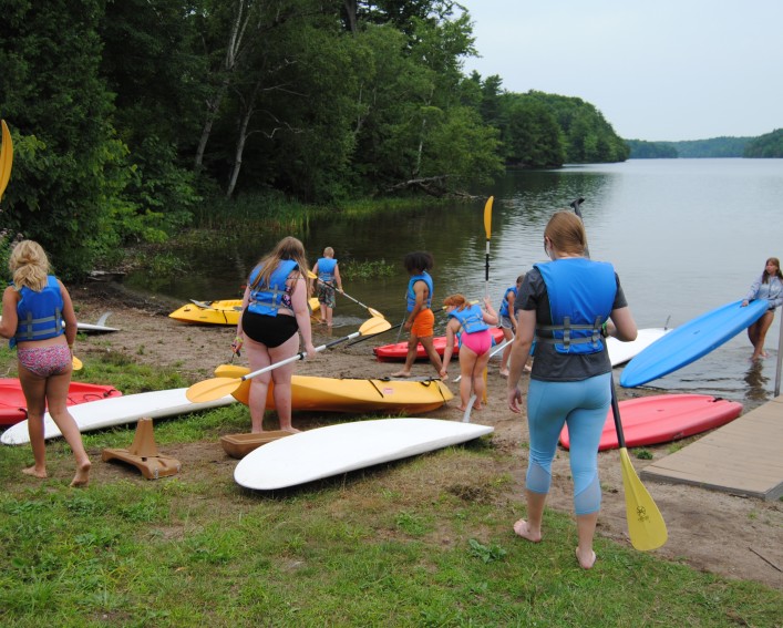 youth with kayaks by the water