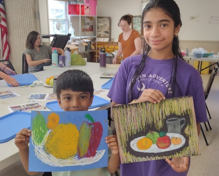 Two children show off their paintings 
