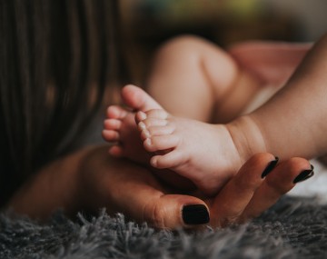 a mother holding her baby's feet 