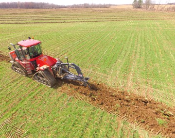 A tractor digging a trench for tile drainage (photo credit to Cayuga Co Soil and Water Conservation District)