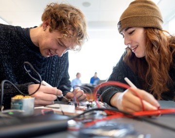 Two students work together to build a robot. 