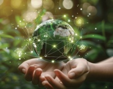 Person holding a hologram of the earth in their hands against a green background