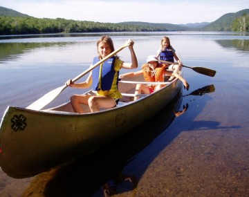 4-H participants rowing a canoe on lake.