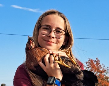 A girl holds a chicken
