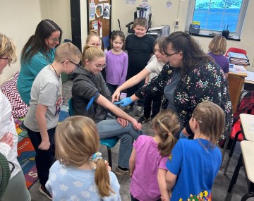 group of children in circle watching a demonstration