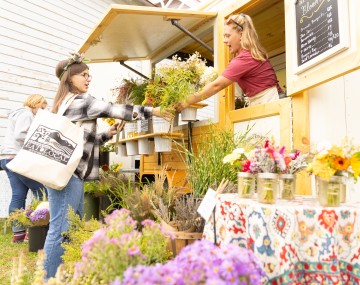 woman selling flowers to customer at festival