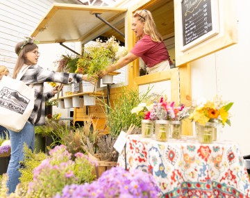 woman selling flowers to customer at festival
