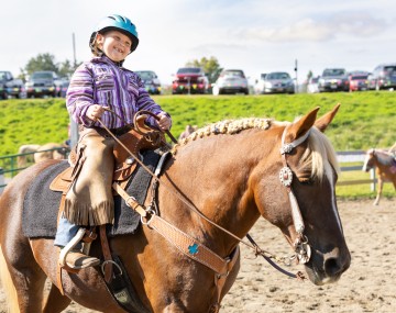 A young girl rides a horse