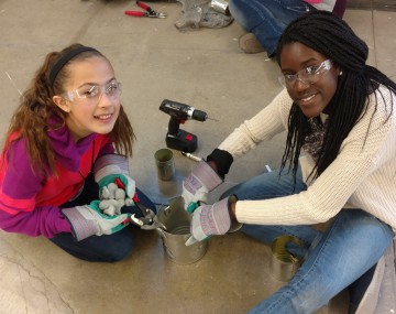 two girls experimenting with biofuel stove