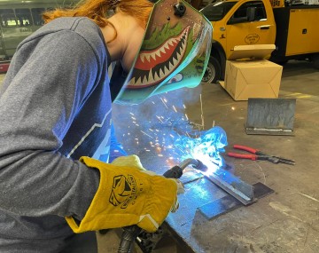 girl operating welder