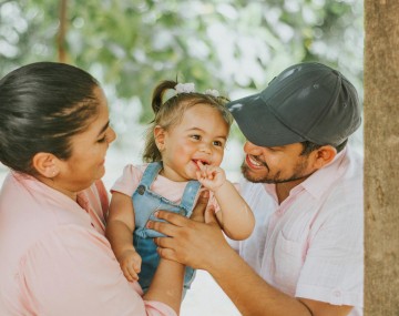 two parents smiling at their child