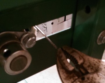 Close up of pliers on the outside of the housing of a conveyor produce washer pulling the splicing bar out.